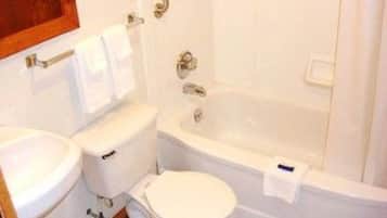 Kombinasi shower/bathtub, handuk, dan tisu toilet