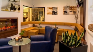 A modern lounge area with a curved sofa, a glass coffee table, and a seating arrangement. - Holiday Inn Express Bremen Airport by IHG (Bremen)