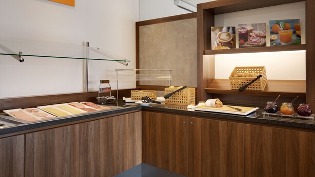 A breakfast bar with a variety of food items and condiments. - Holiday Inn Express Bremen Airport by IHG (Bremen)