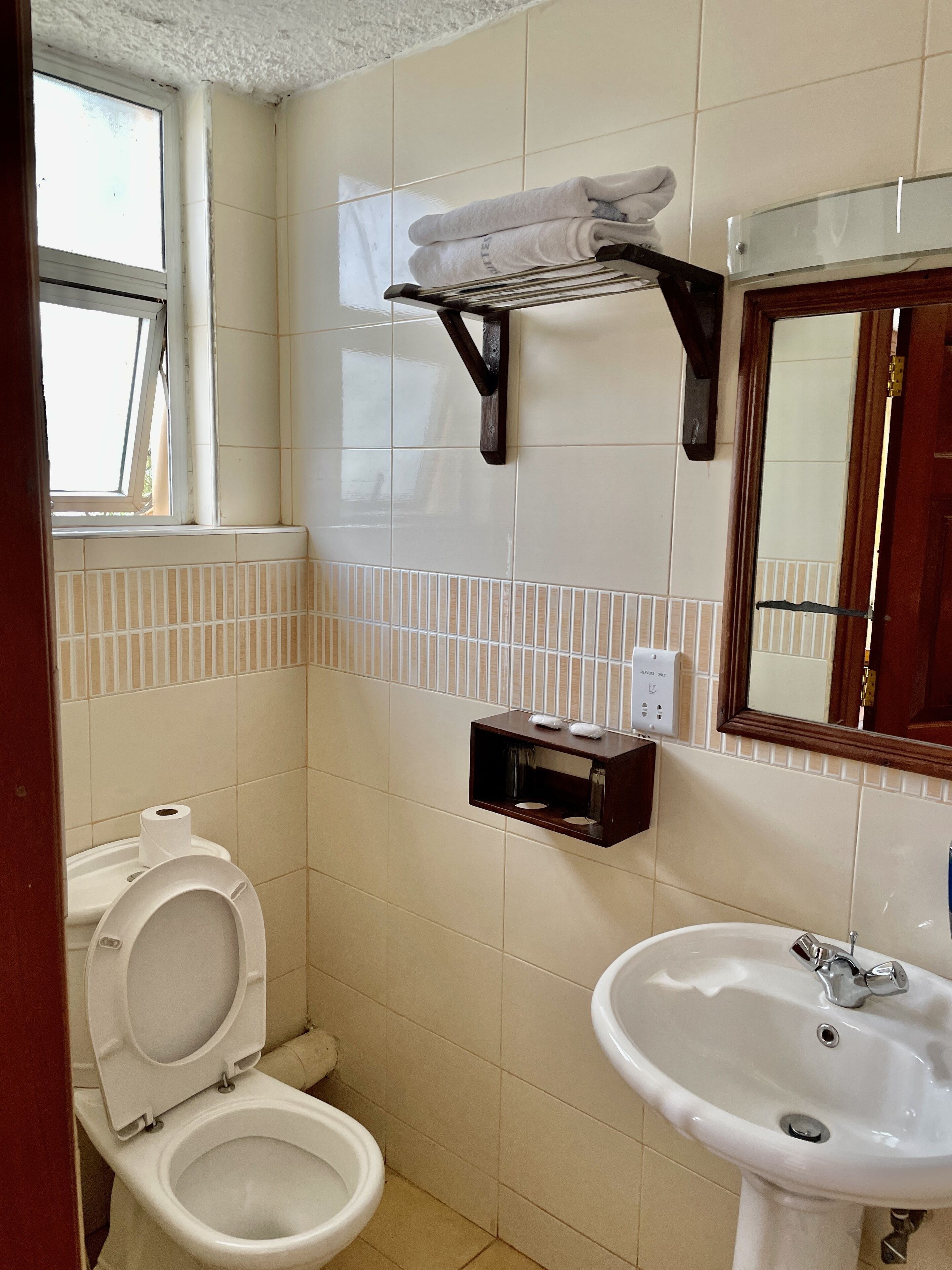 A small bathroom with a toilet, a sink, and a towel rack.