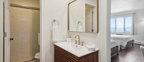 Une salle de bain moderne avec un lavabo blanc, un meuble-lavabo en bois et un grand miroir.