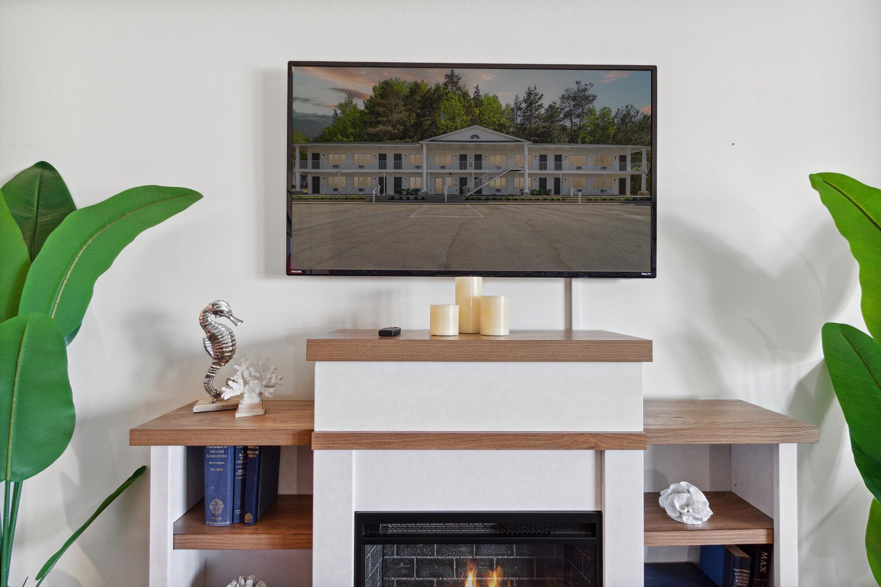 A fireplace with a flat-screen TV above it, displaying a building.