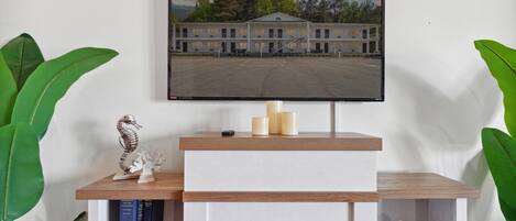 A fireplace with a flat-screen TV above it, displaying a building.