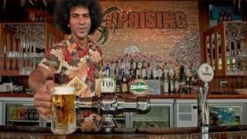 A bar with a beer tap and a glass of beer.