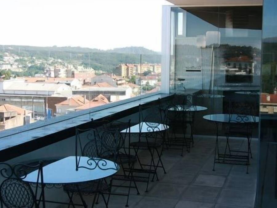A balcony with outdoor seating and a view of a cityscape.