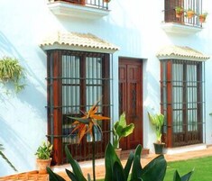 Un edificio de dos pisos con ventanas grandes y un balcón.