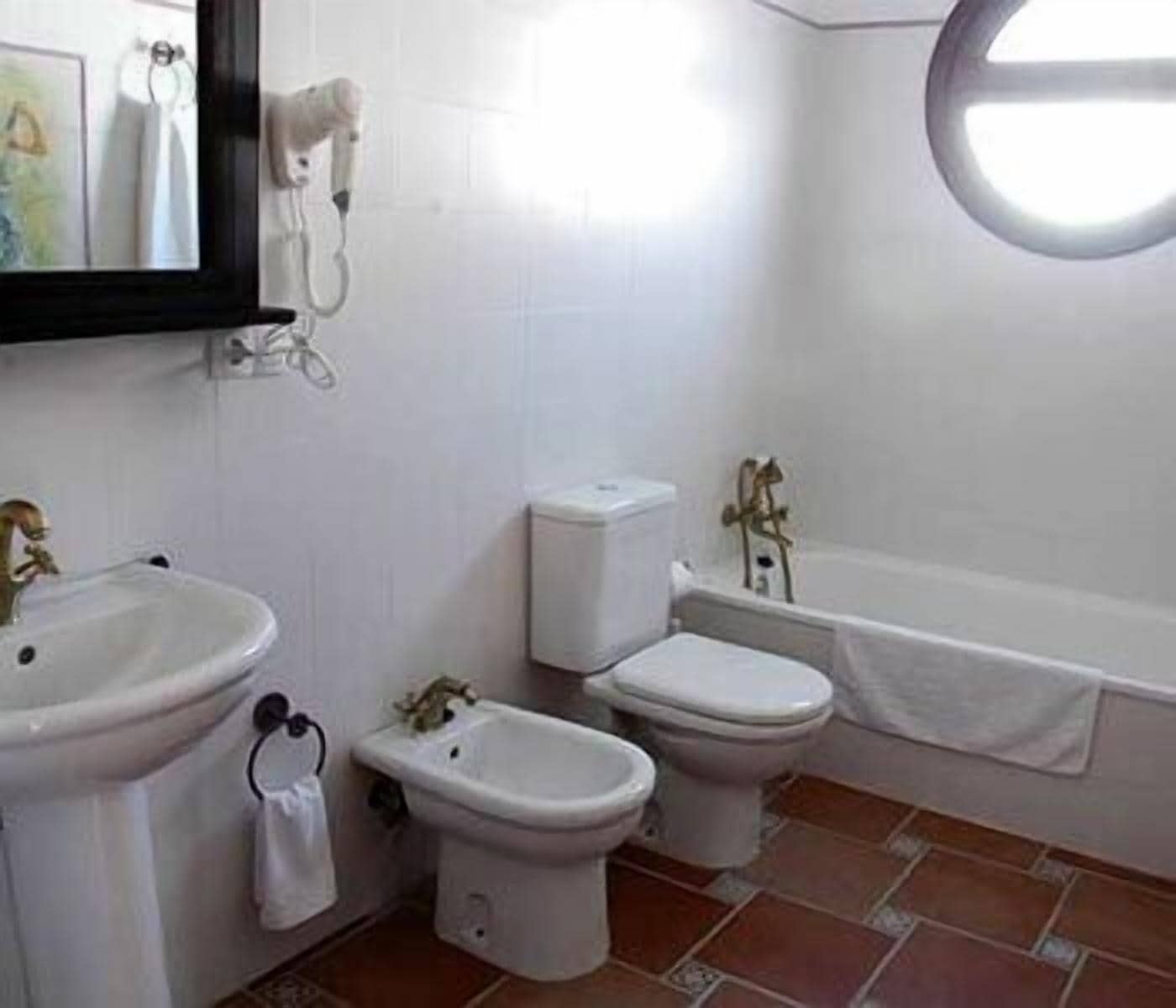 Un baño con lavamanos, bidé, inodoro y bañera.