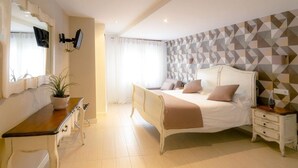 A bedroom with a bed, bedside table, nightstand, and a mirror. - Hotel & Spa Arha Potes (Potes)