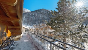 A wooden balcony with metal railings overlooking a snowy mountain landscape. - Banyan Hotel (Sankt Anton am Arlberg)