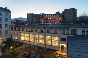 A multi-story building with large windows and a parking area in front. - Hotel Etol (Baden-Baden)