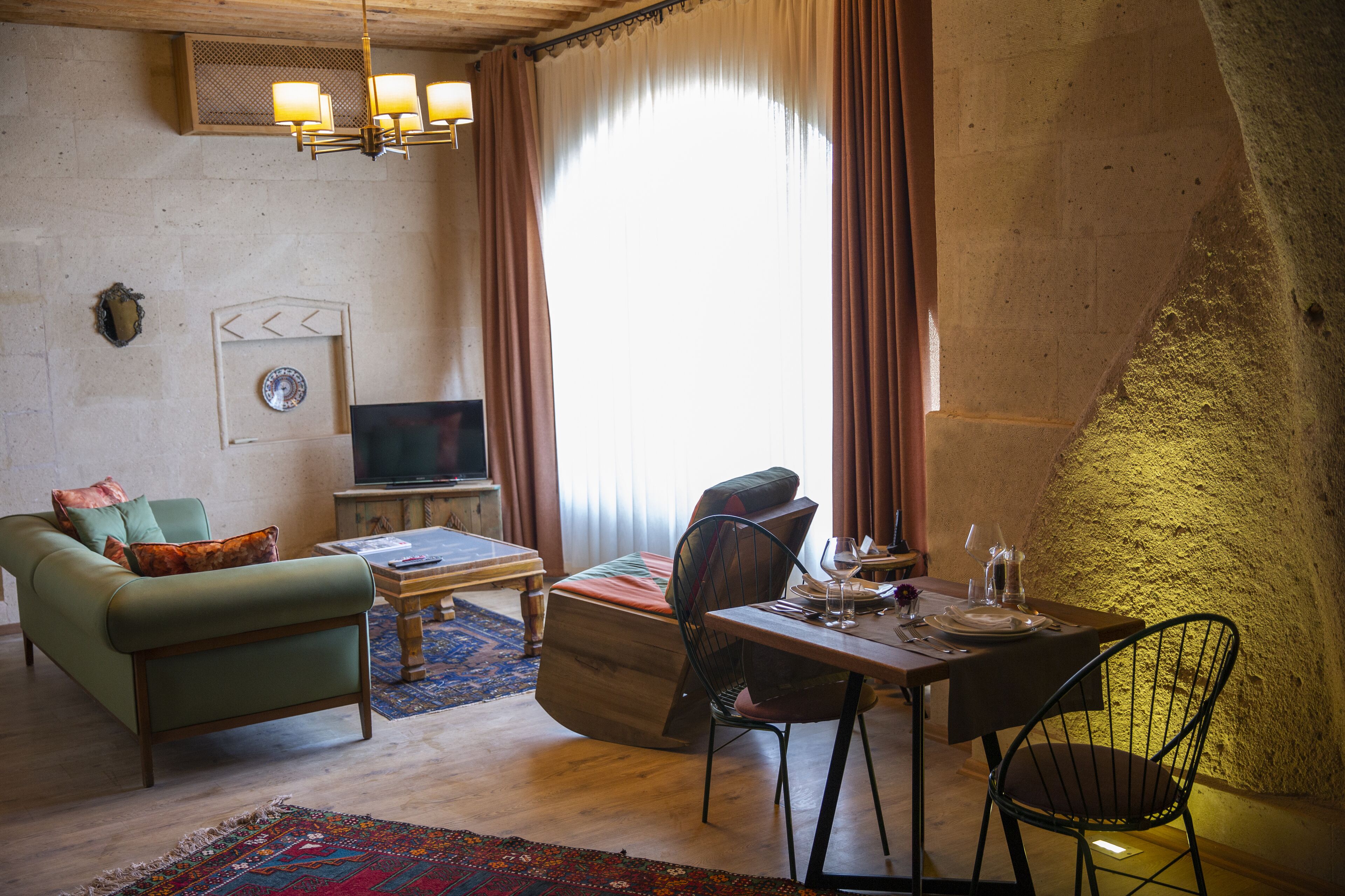 A cozy living room with a sofa, a coffee table, and a dining table set for two.