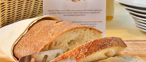 A loaf of bread with a sign indicating it is homemade bread from the producer's own production.