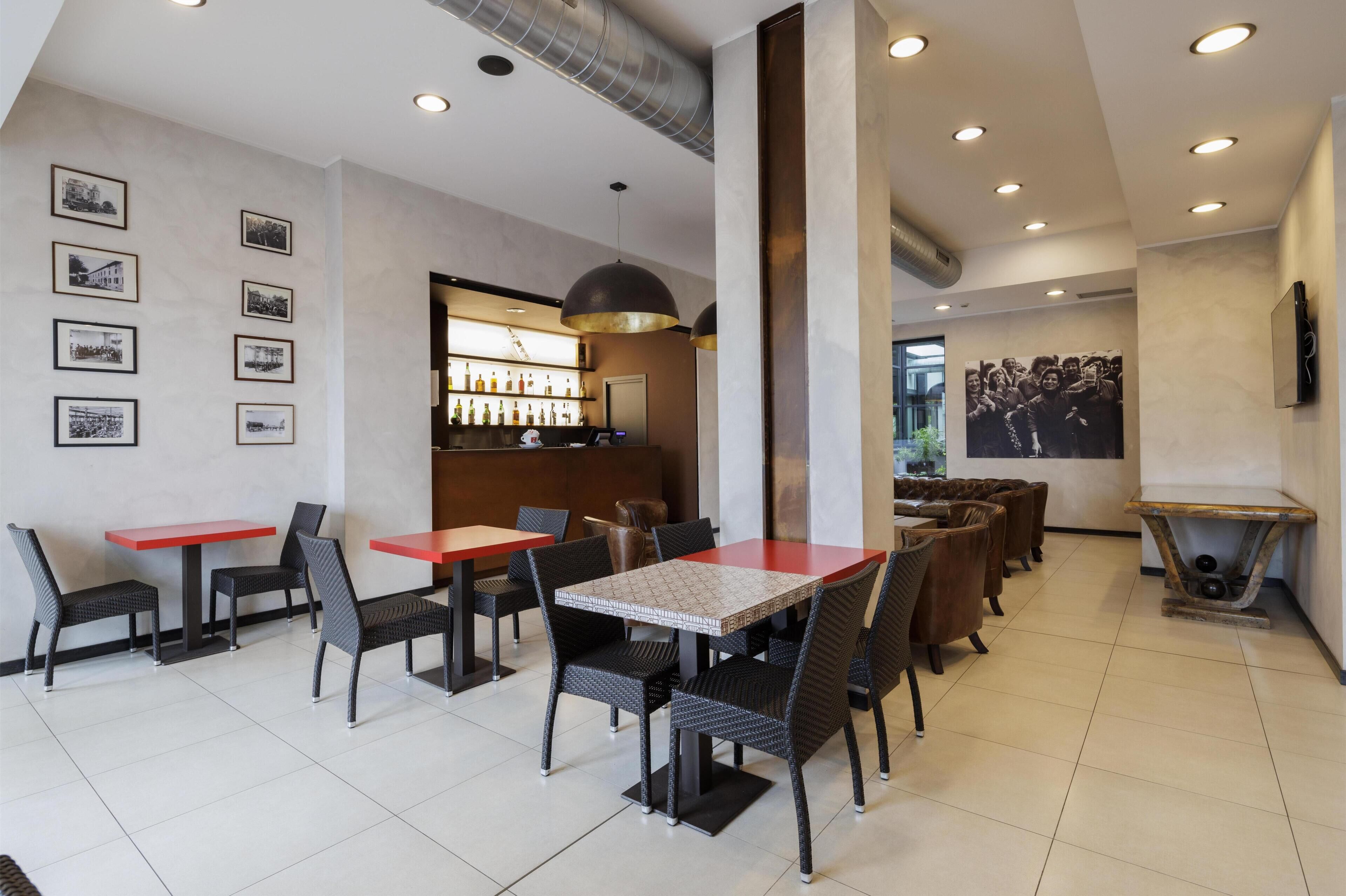 A restaurant with tables and chairs, a bar area, and framed pictures on the wall.
