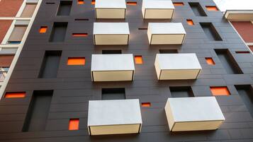 A modern building with multiple balconies and rectangular windows.