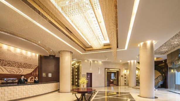 Un vestíbul ampli amb una taquilla d'admissió, una paret decorativa i una escala.