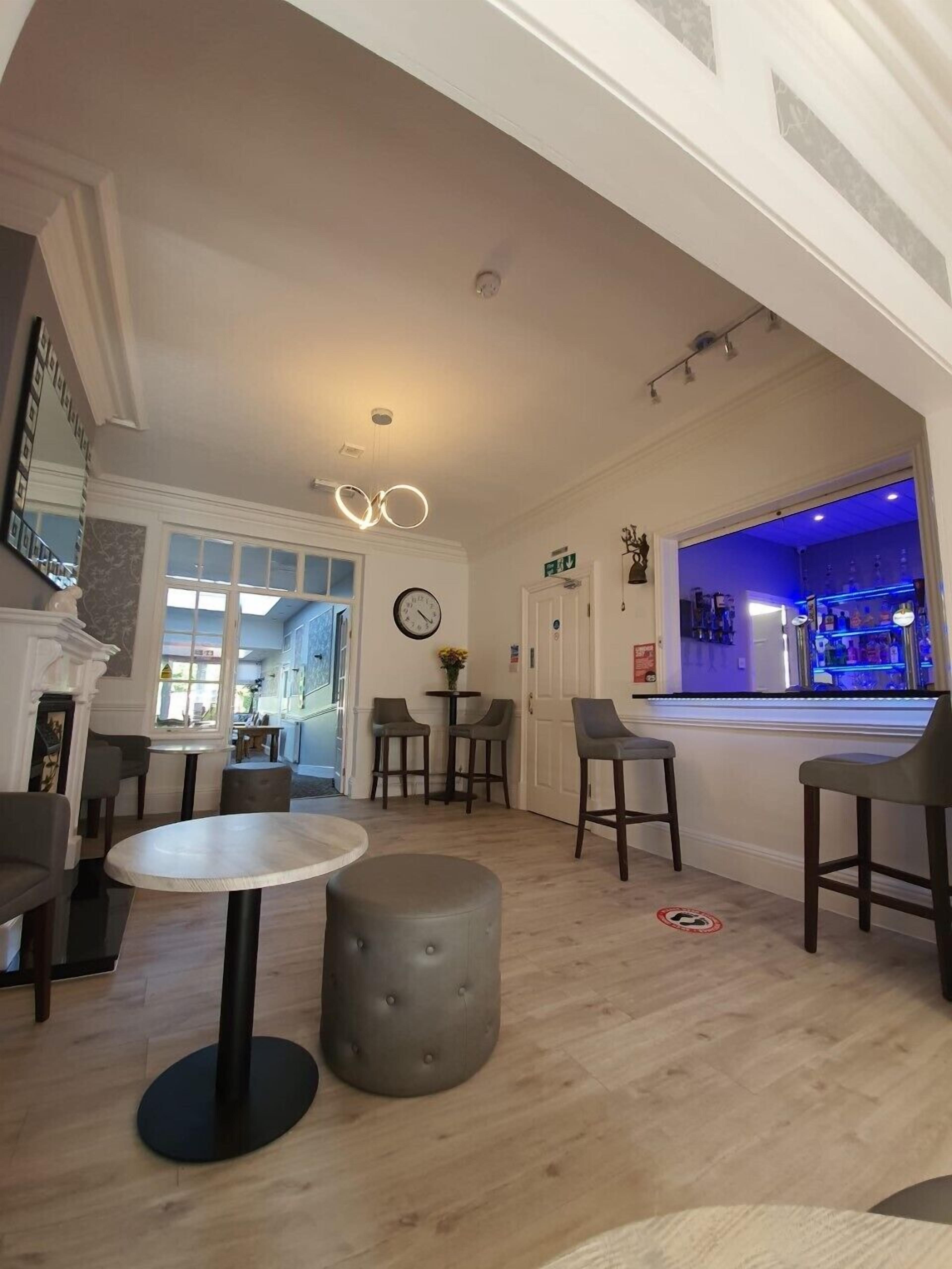 A modern interior with a bar area, seating, and a fireplace.