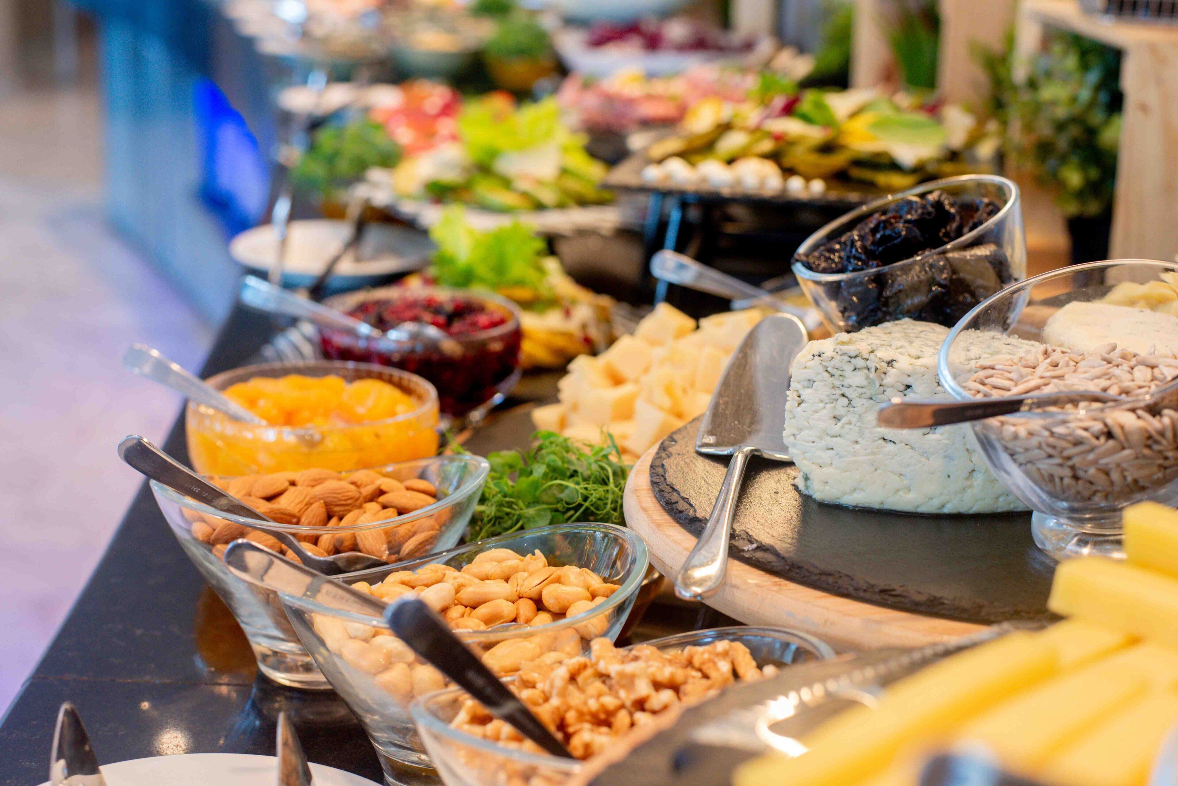 Ein Buffet mit verschiedenen Speisen, darunter Nüsse, Käse und Früchte.