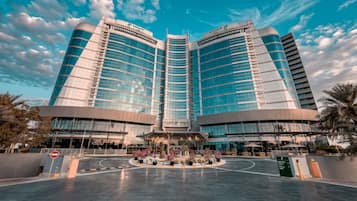 A modern hotel with a central atrium, large glass windows, and a prominent Holiday Inn sign.