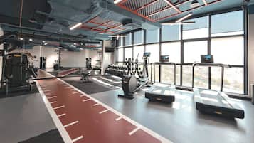 A gym with treadmills, dumbbells, and exercise equipment.