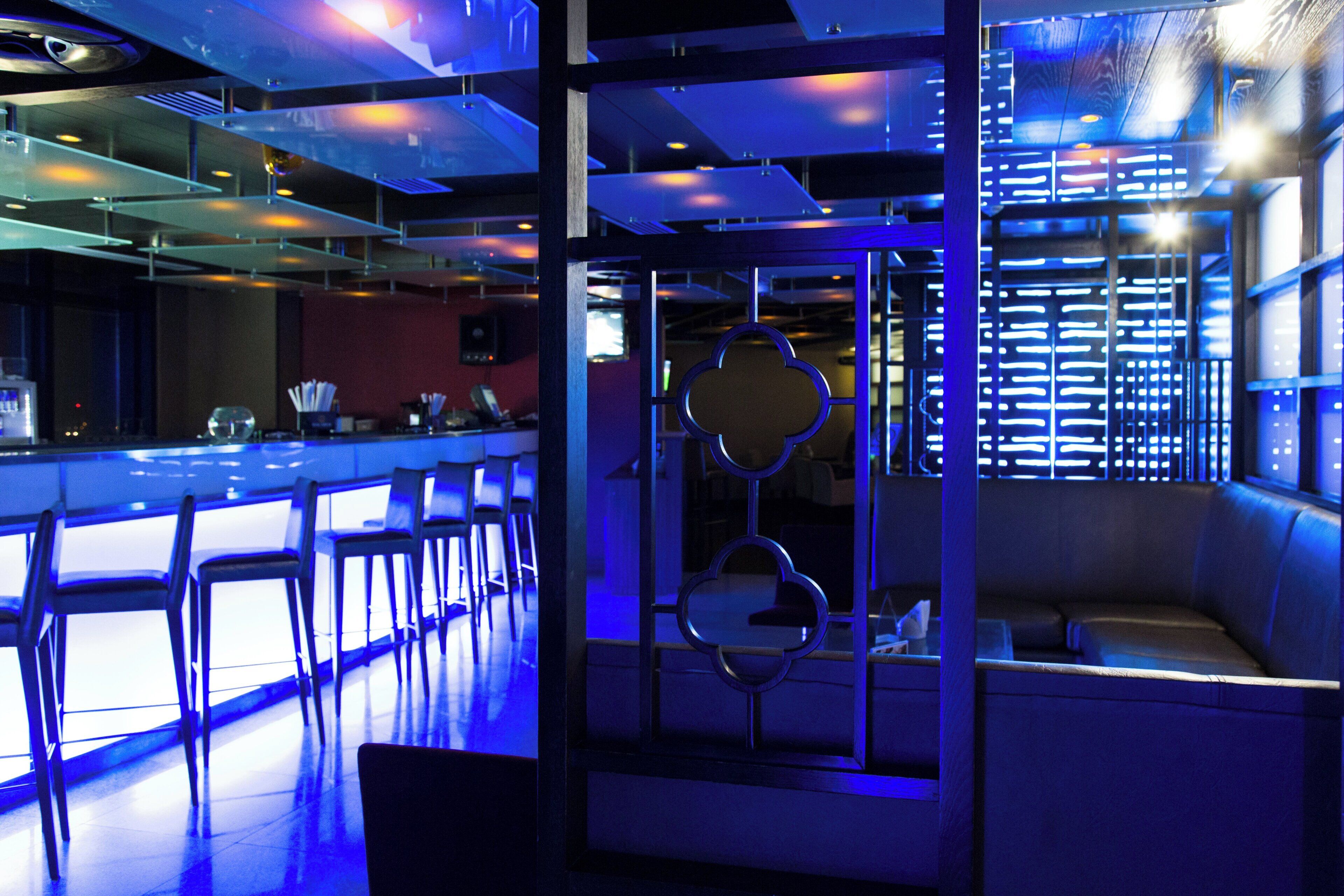 Un área de bar moderna con mostrador y asientos.