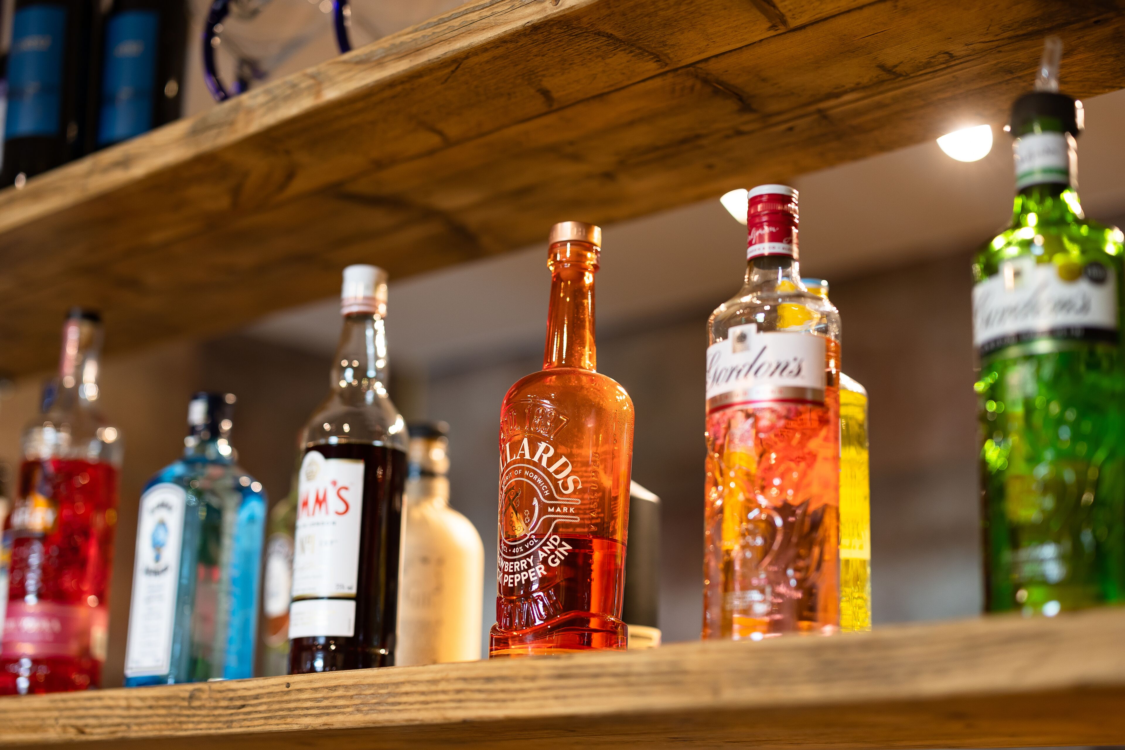 Un estante de madera con diferentes botellas de licor.