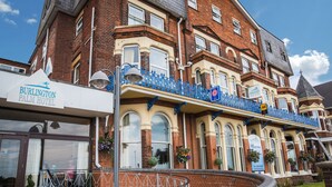 A historic hotel with a prominent balcony, large windows, and a brick facade. - The Palm Court Hotel (Great Yarmouth)