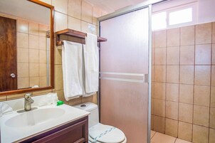 Un baño con lavabo, espejo, toallero, inodoro y cabina de ducha.