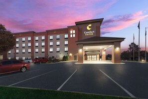 A Comfort Suites hotel with a modern design, featuring a well-lit entrance and a parking lot. - Comfort Suites Columbus East Broad (Columbus)
