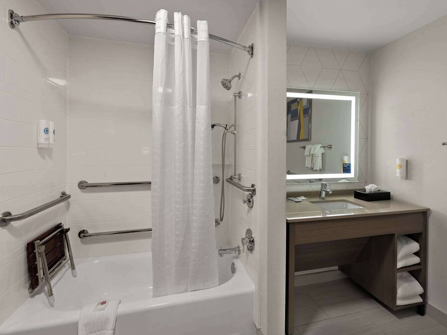 A modern bathroom with a bathtub, shower, and vanity.