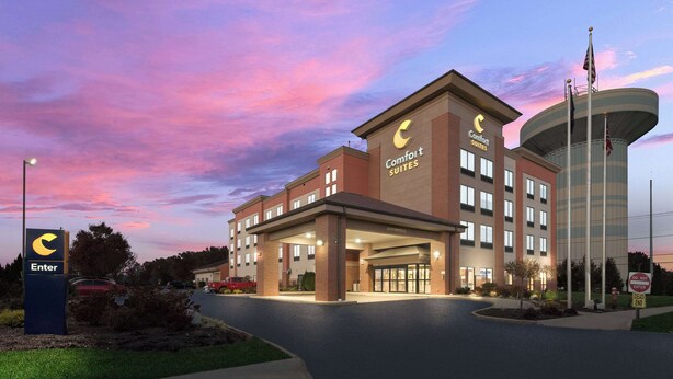 A Comfort Suites hotel with a modern design, featuring a prominent entrance and a large water tower. - Comfort Suites Columbus East Broad (Columbus)