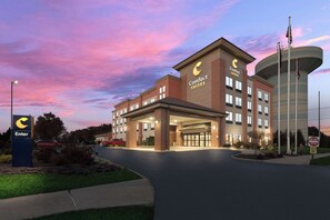 A Comfort Suites hotel with a modern design, featuring a prominent entrance and a large water tower. - Comfort Suites Columbus East Broad (Columbus)