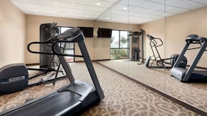 A gym with treadmills, a weight machine, and a mirrored wall. - University Hotel - Davis Area by IHG (Dixon)