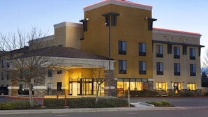 A hotel with a central entrance, multiple floors, and a flat roof. - University Hotel - Davis Area by IHG (Dixon)
