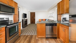 A modern kitchen with wooden cabinets, stainless steel appliances, and a granite countertop.