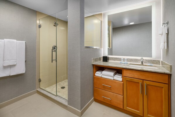 A modern bathroom with a glass-enclosed shower, a large mirror, and wooden cabinets. - HYATT house Fort Lauderdale Airport & Cruise Port (Dania Beach)