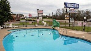 A swimming pool with a sign for Kings Inn, a donut shop, and a lifeguard sign. - Kings Inn (Lenoir City)