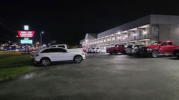 A motel with a row of rooms, a parking lot with several cars, and a sign for the Inn of Lenoir Motor Lodge.