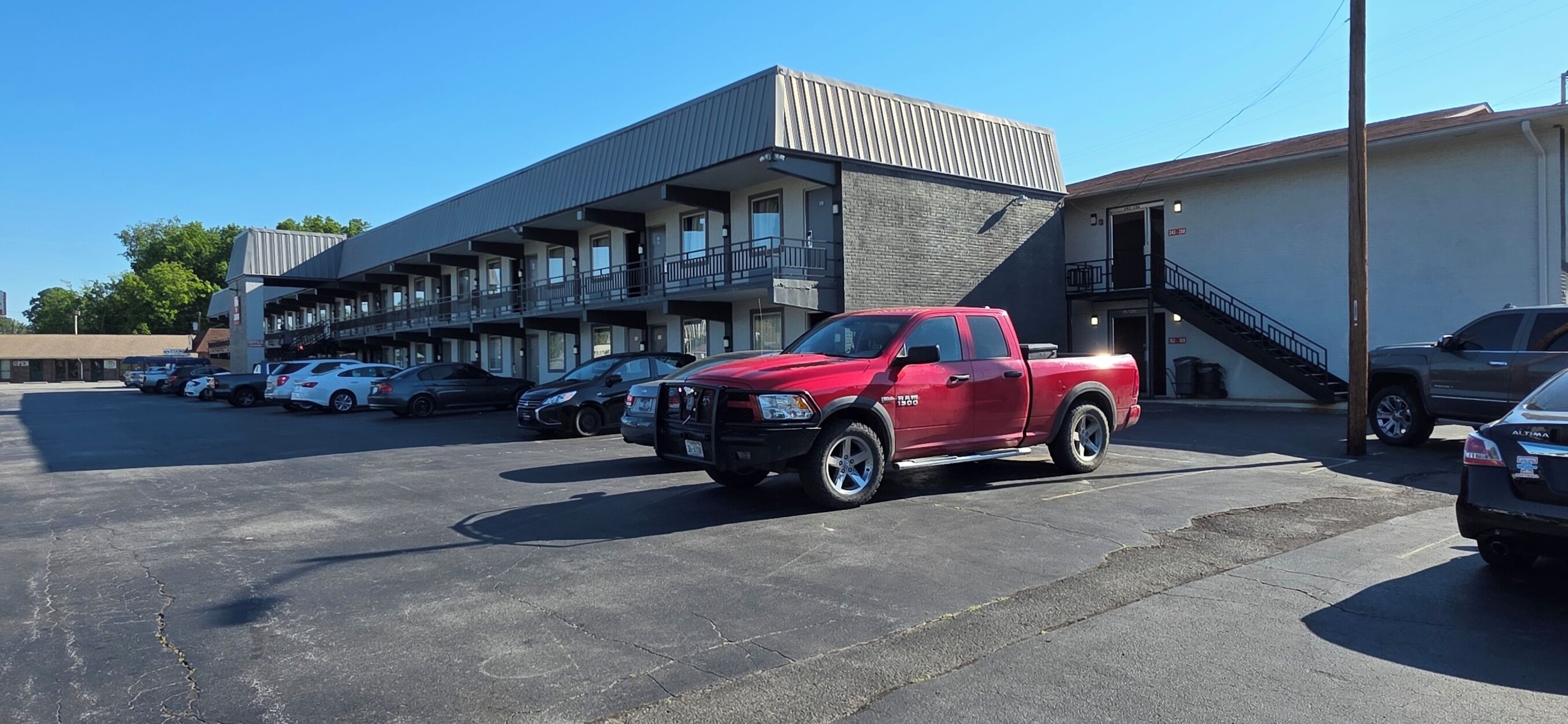 Un parking avec un camionnette rouge garée au premier plan.