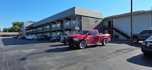A parking lot with a red pickup truck parked in the foreground.