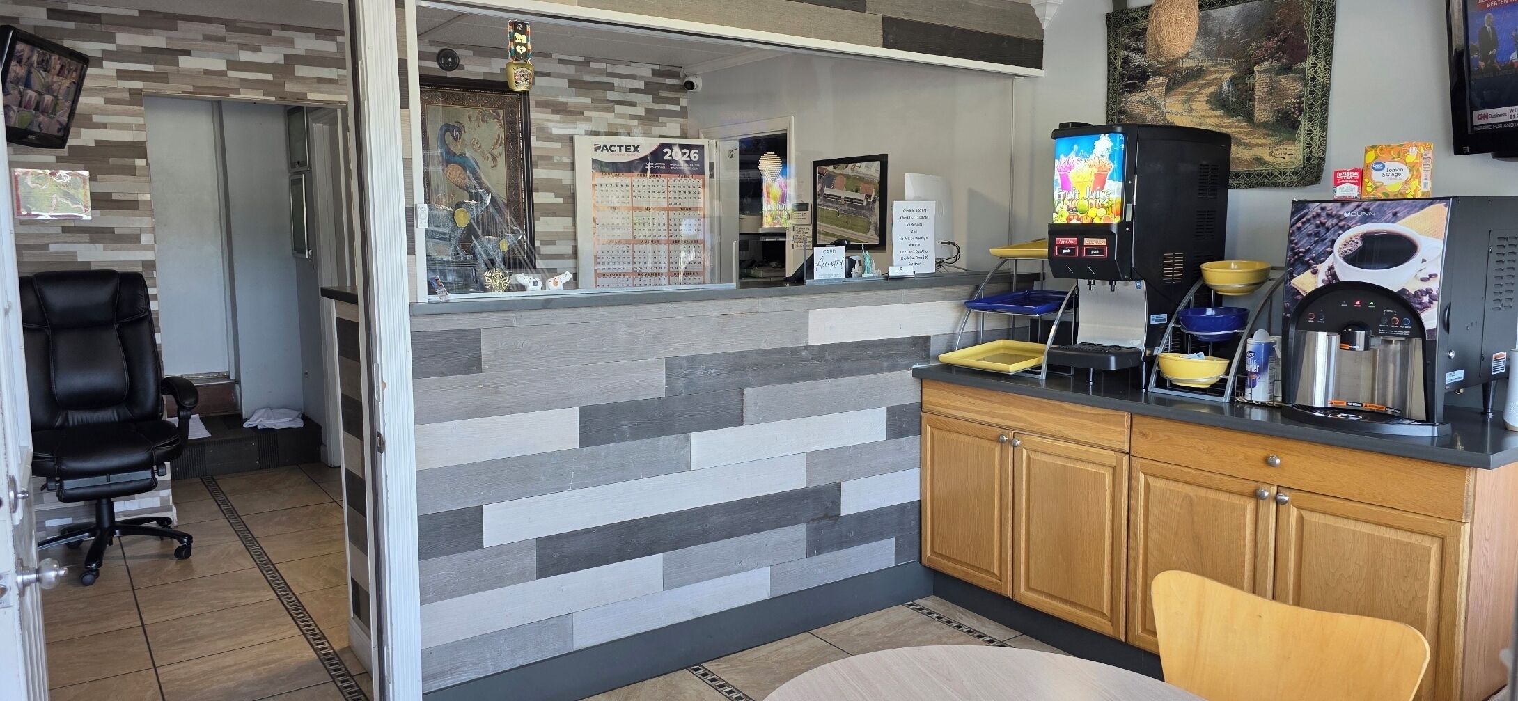 Una cocina moderna con mostrador, cafetera y un calendario en la pared.