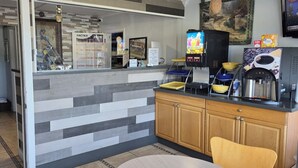 A modern kitchen with a counter, coffee machine, and a calendar on the wall. - Inn Of Lenoir Motor Lodge (Lenoir City)
