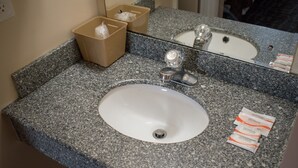 A granite countertop bathroom sink with a mirror above it. - Inn Of Lenoir Motor Lodge (Lenoir City)