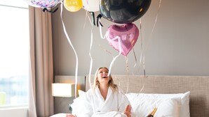 A hotel room with a bed, pillows, a bedside table, and a lamp. - Pullman Adelaide (Adelaide)