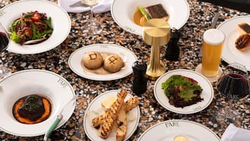 Een tafel met diverse gerechten, een wijnglas en een peper- en zoutstel.