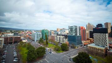 A cityscape with modern buildings, a central intersection, and surrounding greenery.