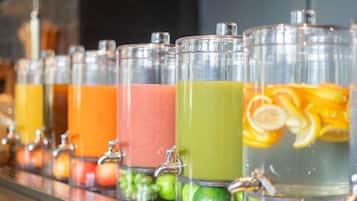 A beverage dispenser with multiple containers, each containing different colored liquids and garnished with fruits.