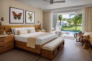 A modern bedroom with a large bed, bedside tables, a bench, and a view of a pool and greenery. - Buccament BAY ALL Inclusive (Kingstown)