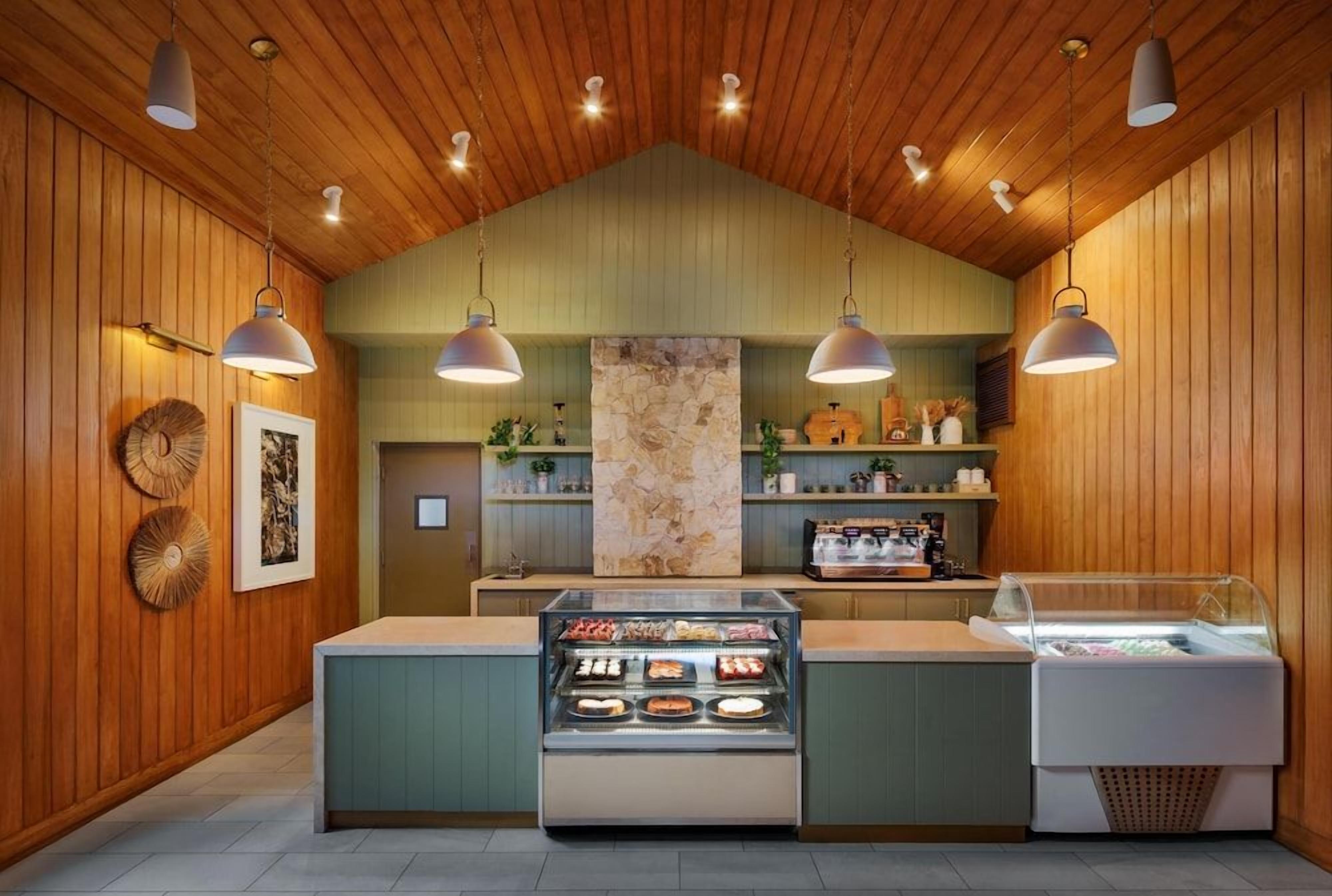 Eine Bäckereitheke mit einer Auslage, hängenden Lampen und Holzvertäfelung.