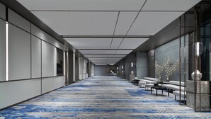 A long, narrow hallway with a patterned carpet, seating areas, and glass walls. - Nanning Marriott Hotel (Nanning)
