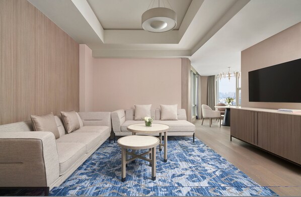 A modern living room with a sectional sofa, a round coffee table, and a flat-screen TV. - Nanning Marriott Hotel (Nanning)